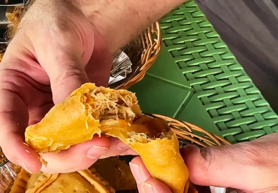Me breaking open a crispy rabbit hops puff pastry to reveal the shredded filling at Hops Grill House in Bacolod