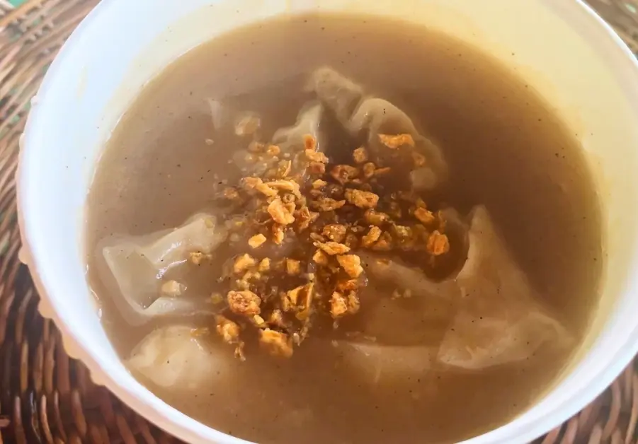 Rabbit dumplings in molo soup, topped with fried garlic.