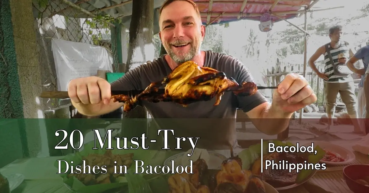 Geoff holding a large skewer of grilled native chicken inasal at Chay Letty in Bacolod, Philippines. A spread of Filipino dishes sits on banana leaves in front of him. The image features a text overlay reading '20 Must-Try Dishes in Bacolod' with 'Bacolod, Philippines' in the corner.