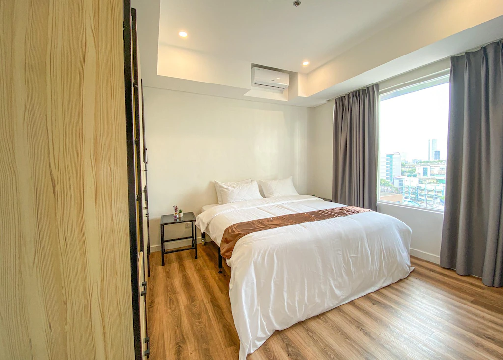 Standard room at Wesfame Suites in Quezon City with corner window view and minimalist furnishings