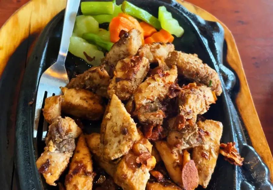 Blue marlin salpicao served on a sizzling plate with vegetables at Little Quiapo