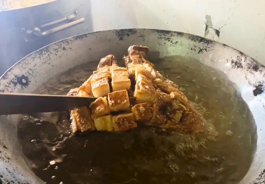 Sliced pork face cubes frying in oil to make Kapalmuks at Pepeton’s Grill