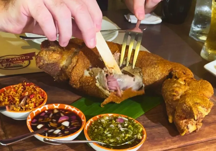 Fork and popsicle stick carving into nuked crispy pata at Livestock QC