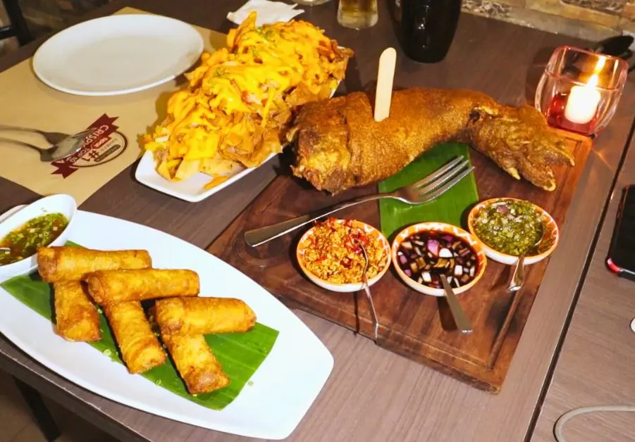 Full table spread at Livestock QC with crispy pata, nachos, and lumpia