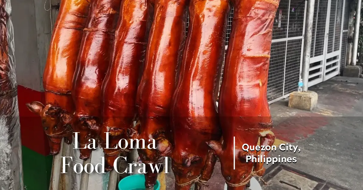 Six whole roasted lechon lined up on stainless steel spits at a lechon stall in La Loma, Quezon City