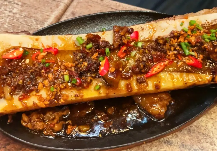 Cheap Eats in Quezon City: Affordable Restaurants and Meals Sizzling bone marrow from Pares Retiro in Quezon City, captured mid-sizzle on a cast iron plate
