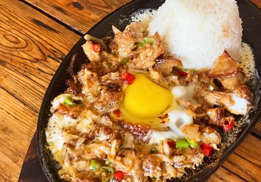 Cheap Eats in Quezon City: Affordable Restaurants and Meals Sizzling plate of Baks Tapsilugan's coco sisig, freshly served and still steaming on a hotplate