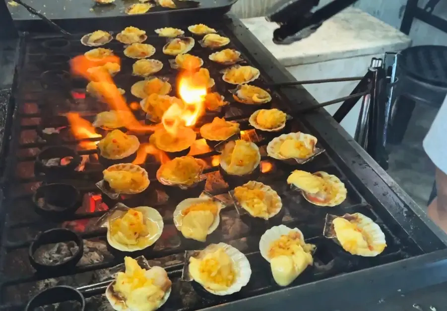 Cheap Eats in Quezon City: Affordable Restaurants and Meals Grilled Scallops in Quezon City served by Ate Patricia at her roadside stall, photographed by Geoff during a local food tour.