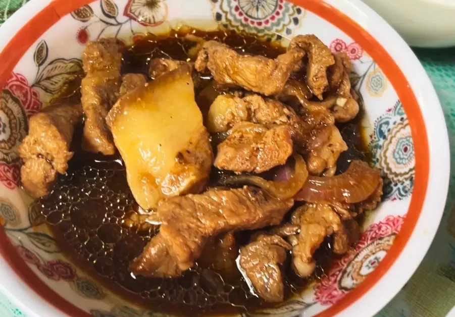 Filipino Street Food: Random Streets in Bago Bantay Filipino pork steak with onions and soy-vinegar sauce served in a ceramic bowl