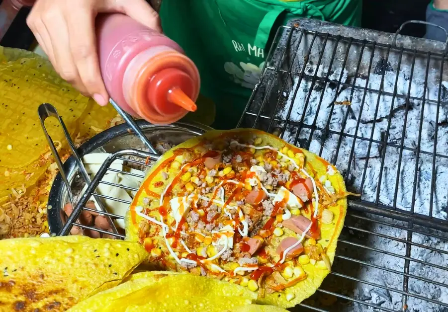 Bánh tráng nướng grilled fresh over charcoal, served hot at Hồ Thị Kỷ food street in Ho Chi Minh City’s District 10.