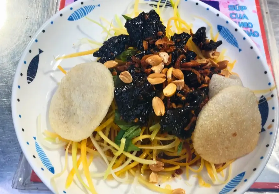 Vietnamese green papaya salad with dried beef (gỏi đu đủ khô bò) served at Hồ Thị Kỷ night market, Saigon.