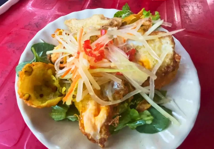Where to Eat in Hoi An Old Town: 9 Iconic locations Plate of bánh khọt pancakes with shrimp and vegetables served at Dung Bánh Can Trứng Cút Banh Cuon Cha Lua in Hoi An.