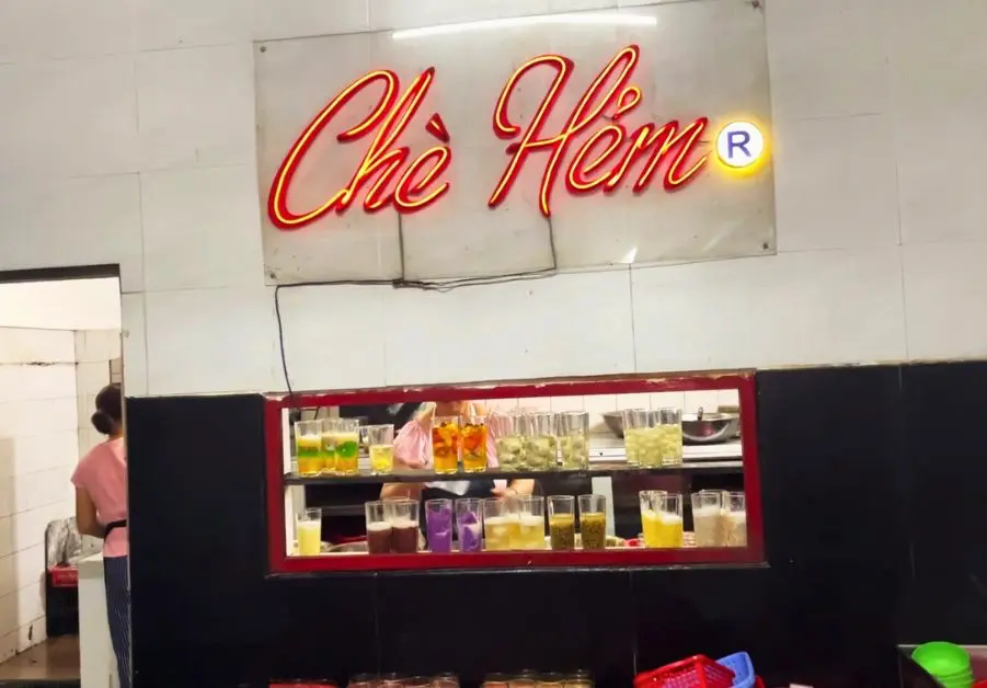 Chè Hẻm dessert shop entrance with neon sign in Hue