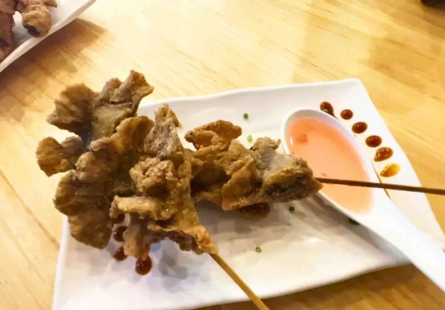 Goto Believe: Kapitolyo's Mind-Blowing Congee Chicharron bulaklak skewers served with vinegar dipping sauce