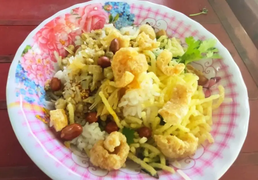 Plate of cơm hến rice with clams, peanuts, and pork skin in Hue