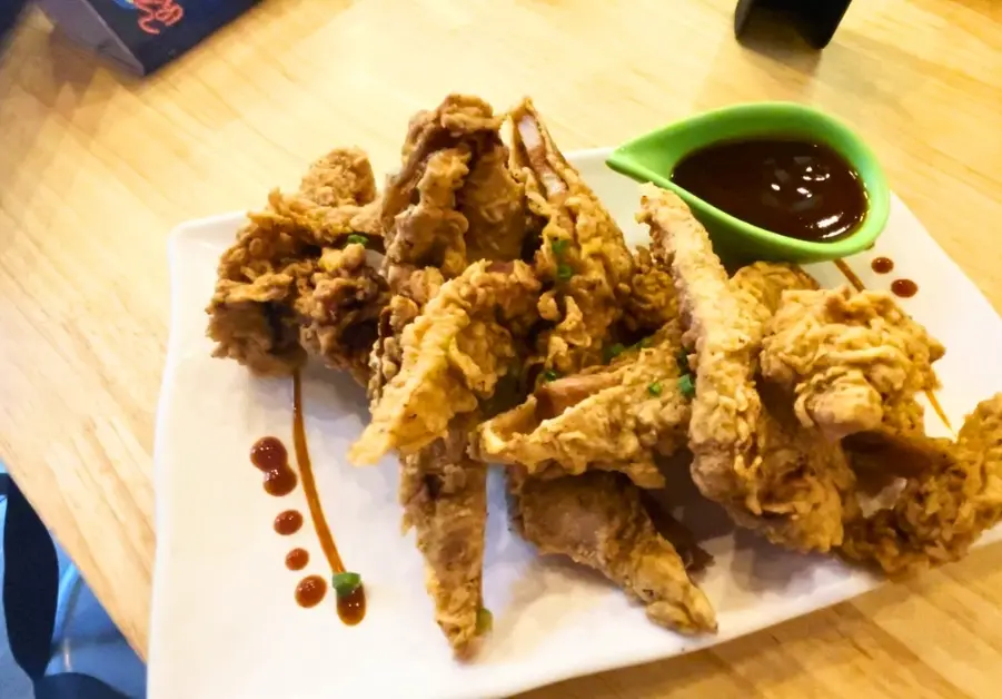 Goto Believe: Kapitolyo's Mind-Blowing Congee Deep-fried liempo strips served with dipping sauce at Goto Believe
