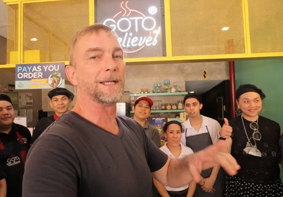 Goto Believe: Kapitolyo's Mind-Blowing Congee Geoff with Goto Believe Kapitolyo restaurant staff in front of counter and signage