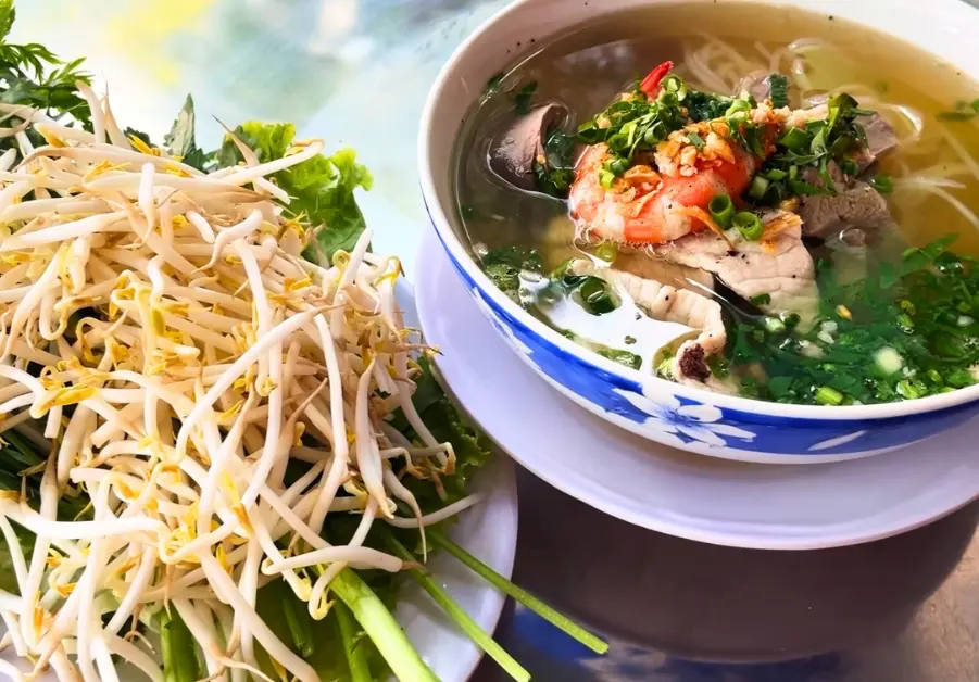 Hủ tiếu with shrimp and pork served with fresh herbs and bean sprouts in Saigon