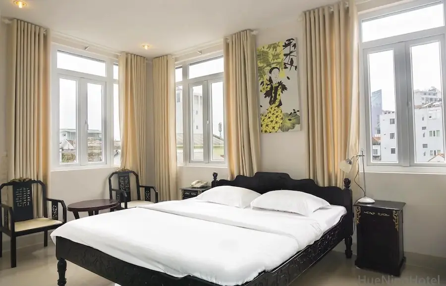 Guest room at Nino Hotel Hue with traditional furniture