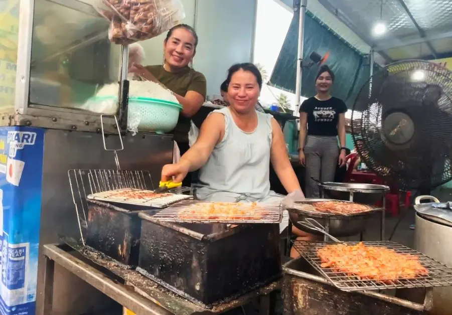 Staff grilling skewers at Mệ Bừ street food restaurant in Hue