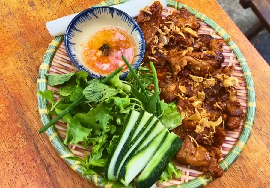 Where to Eat in Hoi An Old Town: 9 Iconic locations Plate of thịt nướng cuốn bánh tráng with grilled pork, vegetables, and dipping sauce at Hy Restaurant Hoi An