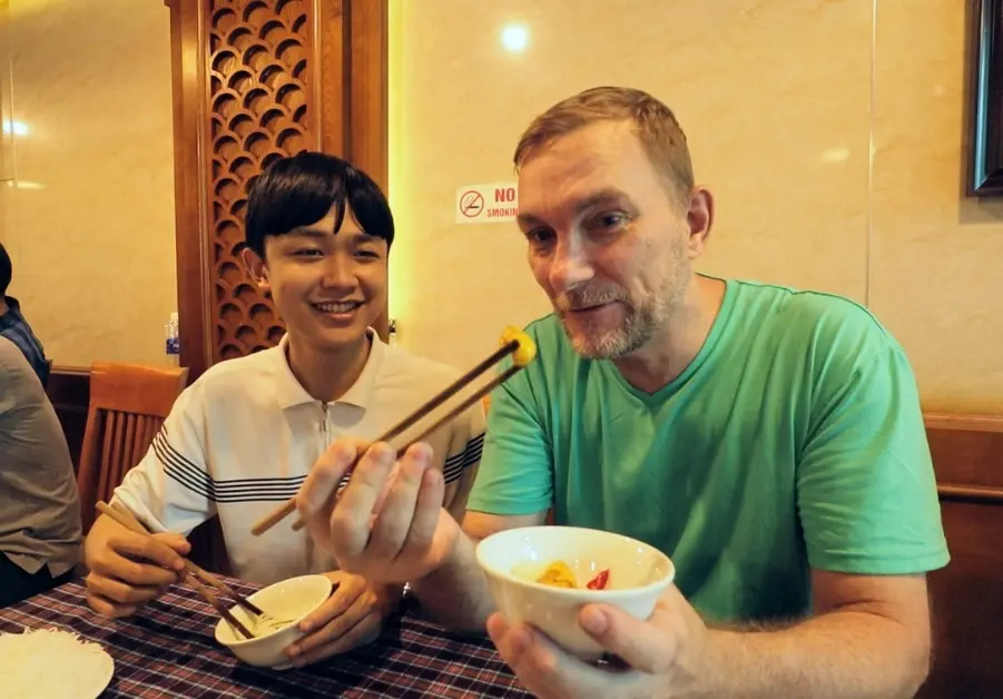 Geoff and Quan displaying fish intestines at Chả Cá at Anh Vũ restaurant in Hanoi
