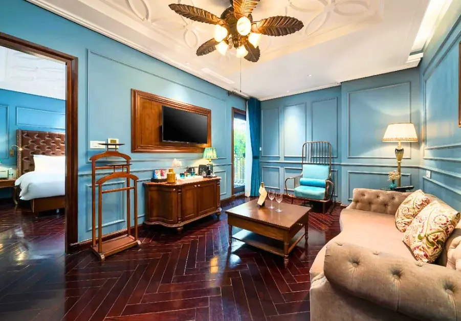 Interior suite at Peridot Grand Luxury Boutique Hotel Hanoi with wooden floors and blue walls.