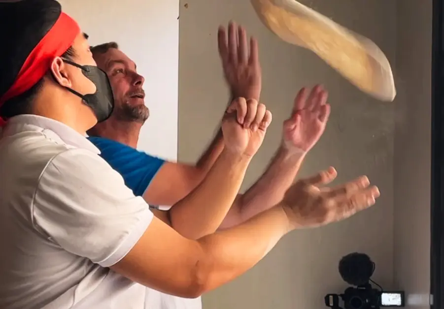 Chef teaching Geoff pizza dough tossing at Amare La Cucina Pasig