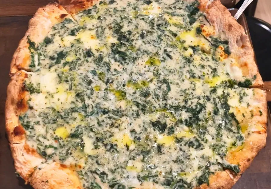 quattro formaggio pizza with spinach and melted cheese at amare la cucina