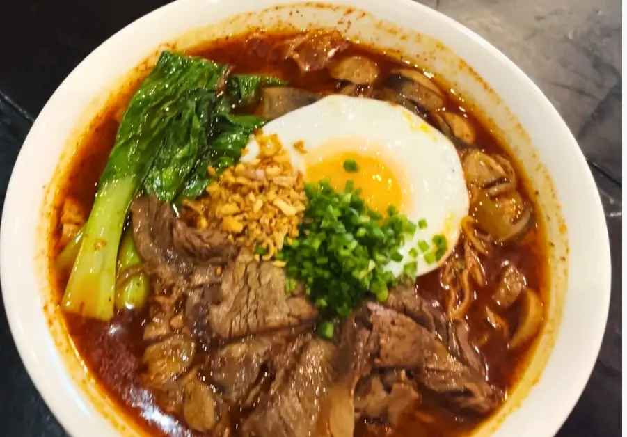 Spicy Szechuan beef noodle soup topped with egg at Caution Hot Kapitolyo