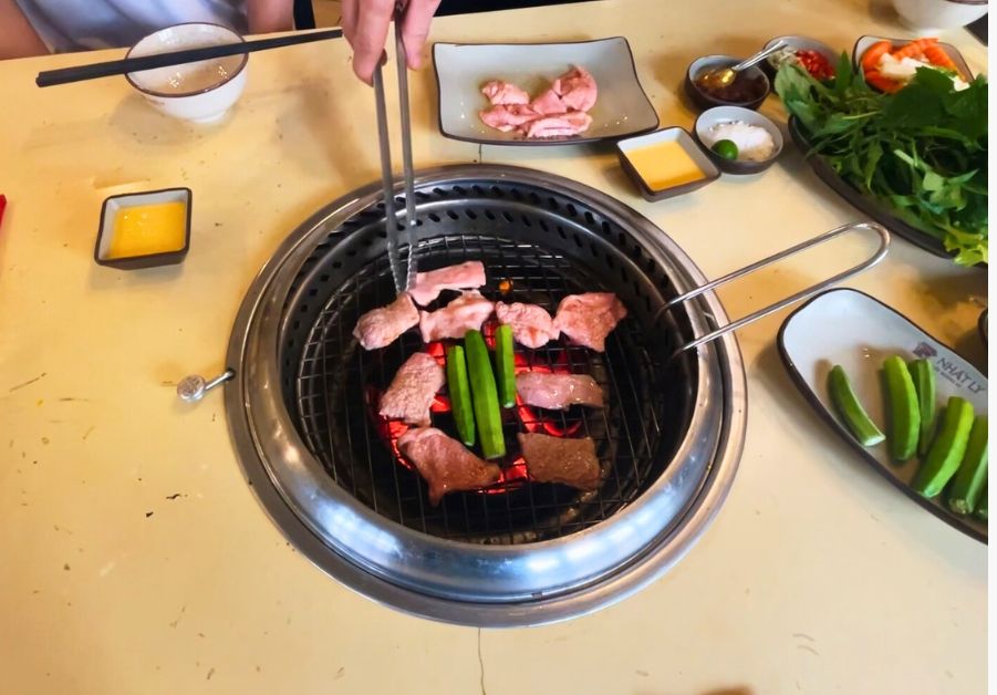 Where to Eat in Hanoi: 18 Iconic Dishes with Locations Grilled goat udders cooking over charcoal with okra at a Ninh Binh grill spot