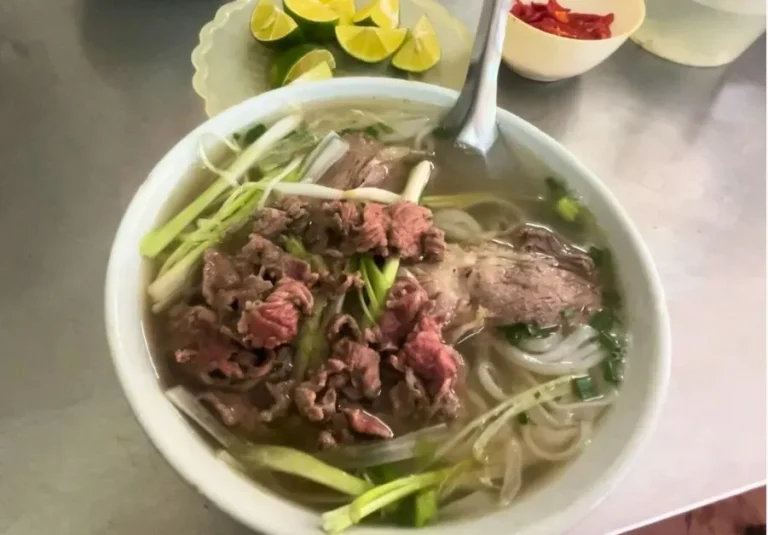 Pho bo with rare beef slices and fresh lime.